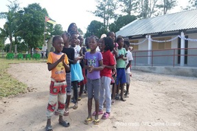 Children gather on the playground outside their classroom